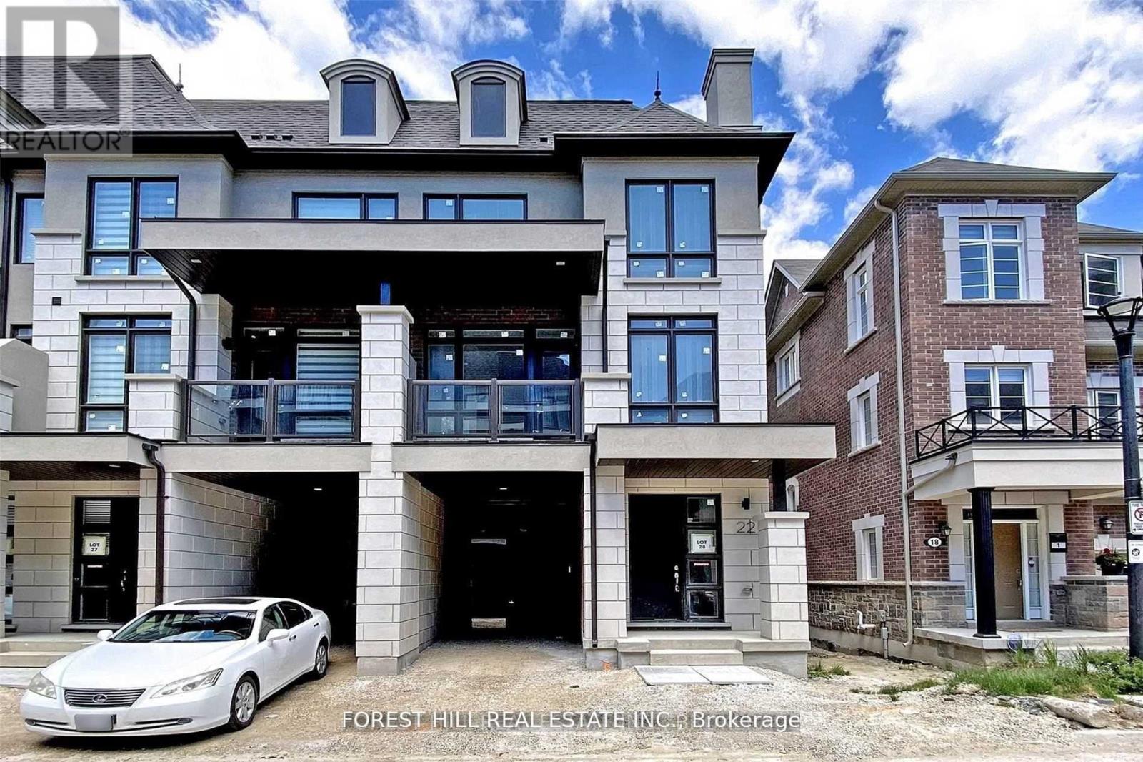 A large, modern house with a car parked in front.