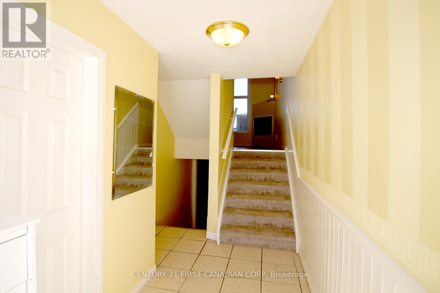 A hallway with a staircase leading to a landing.