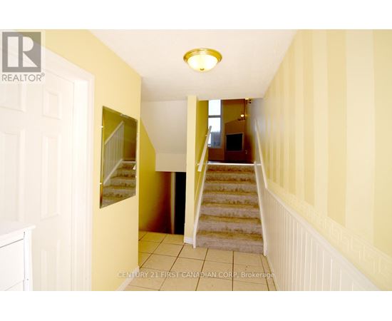A hallway with a staircase leading to a landing.