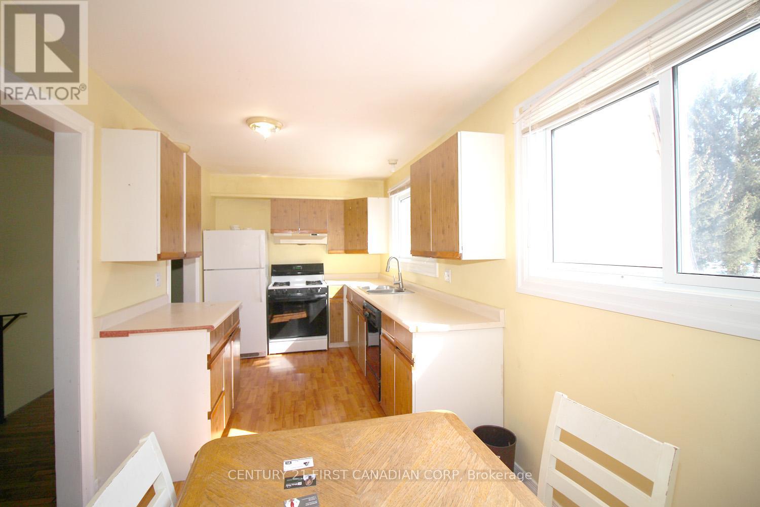 A kitchen with a table and chairs in front of it.