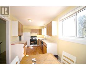 A kitchen with a table and chairs in front of it.