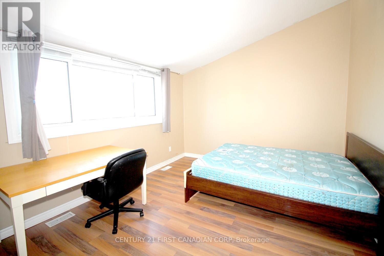 A bedroom with a bed, desk, and chair.