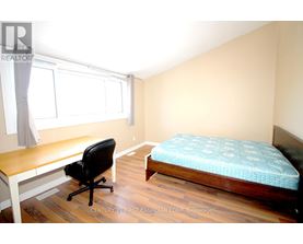 A bedroom with a bed, desk, and chair.