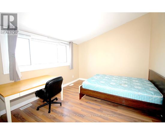 A bedroom with a bed, desk, and chair.