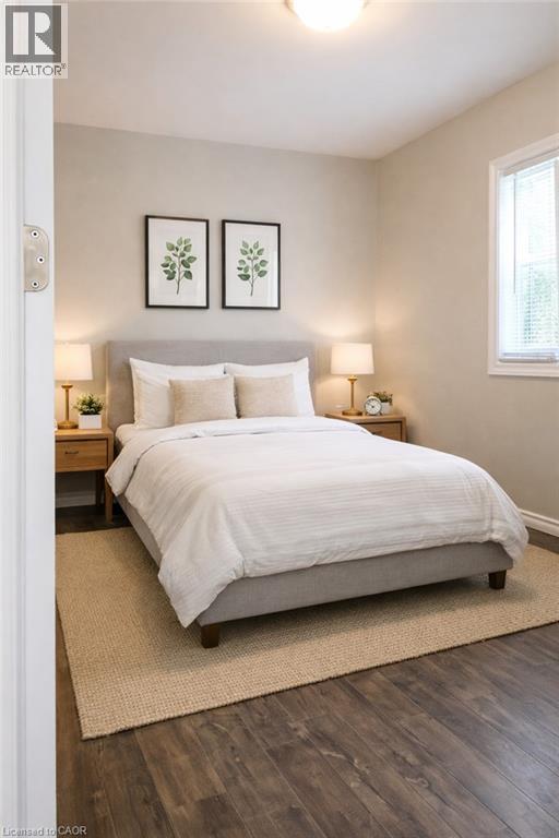 A bedroom with a large bed and two framed pictures on the wall.