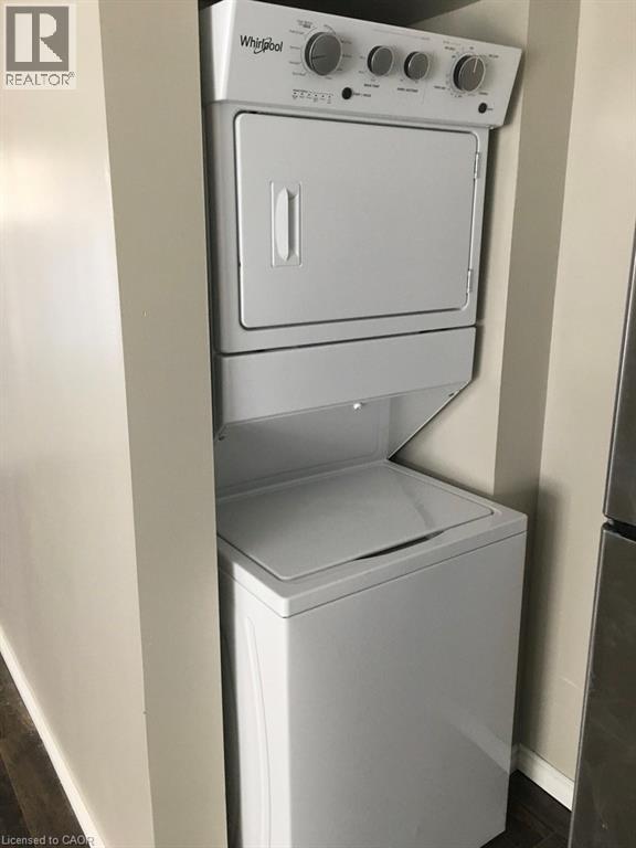 A white Whirlpool dishwasher and dryer stacked on top of each other.