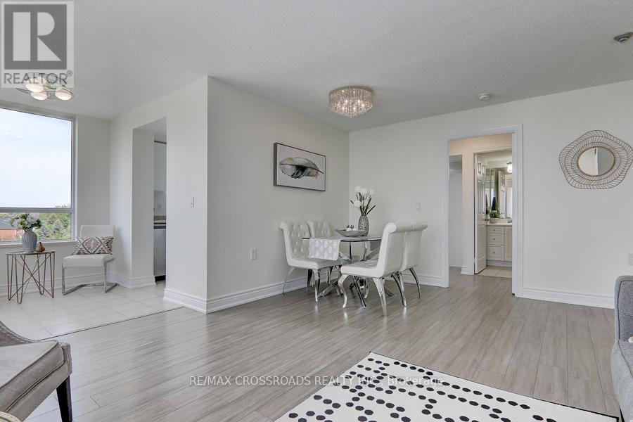 A white dining room with a table set for two and a couch.