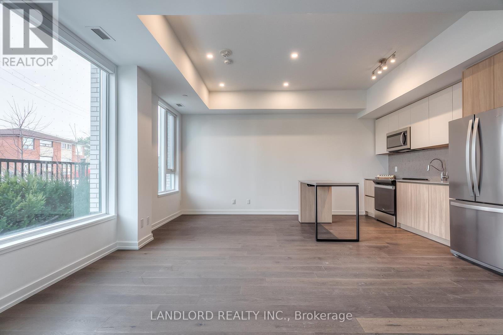 A spacious kitchen with wooden cabinets and stainless steel appliances.
