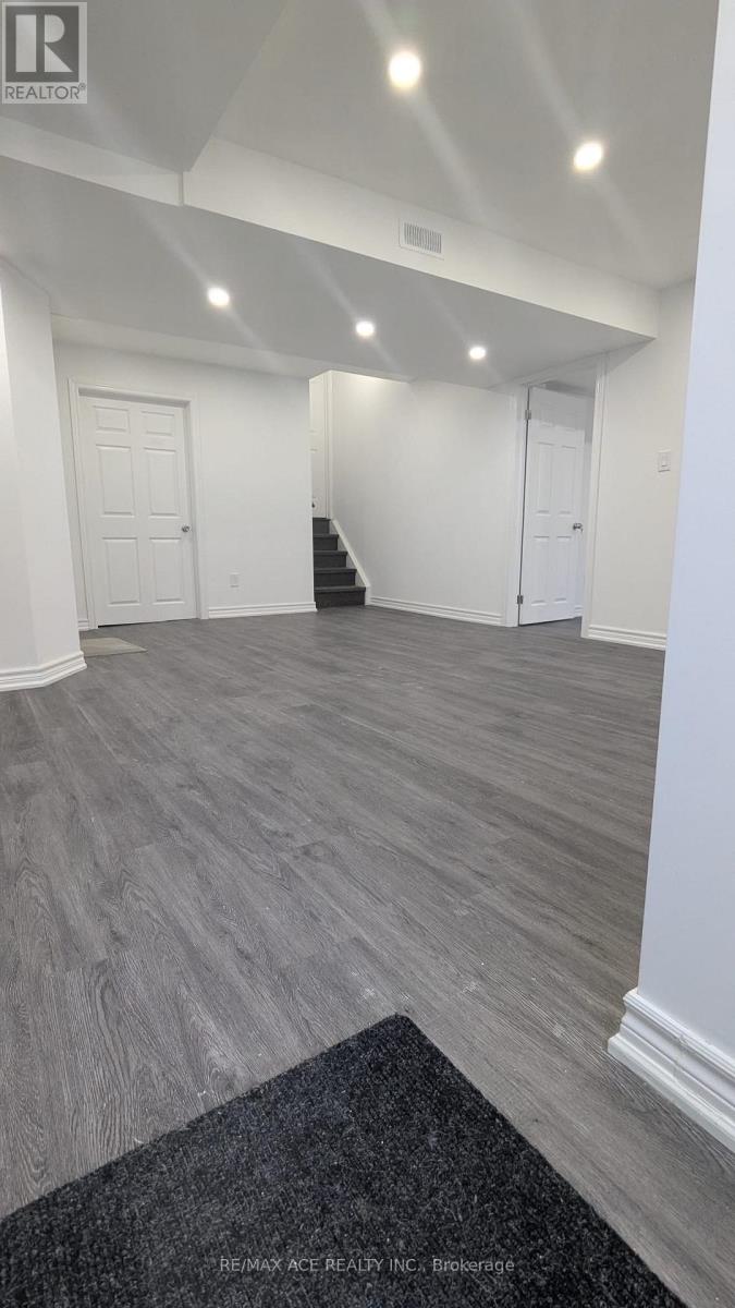 A spacious room with grey flooring and white walls.