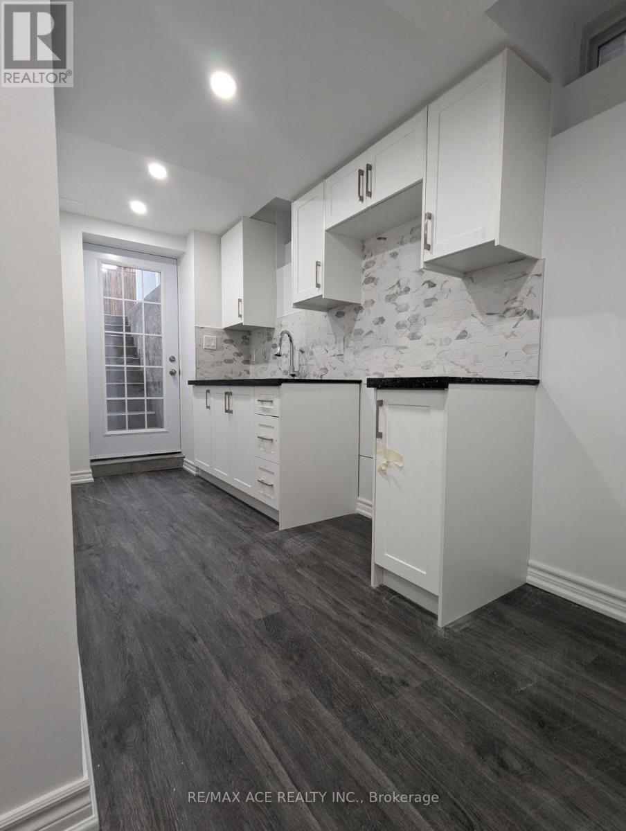 A modern kitchen with white cabinets and a marble backsplash.