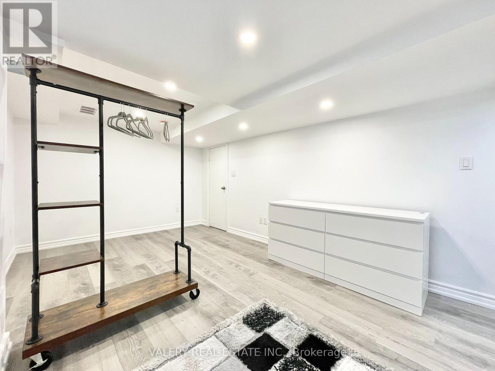 A room with a white wall and a black and white rug.