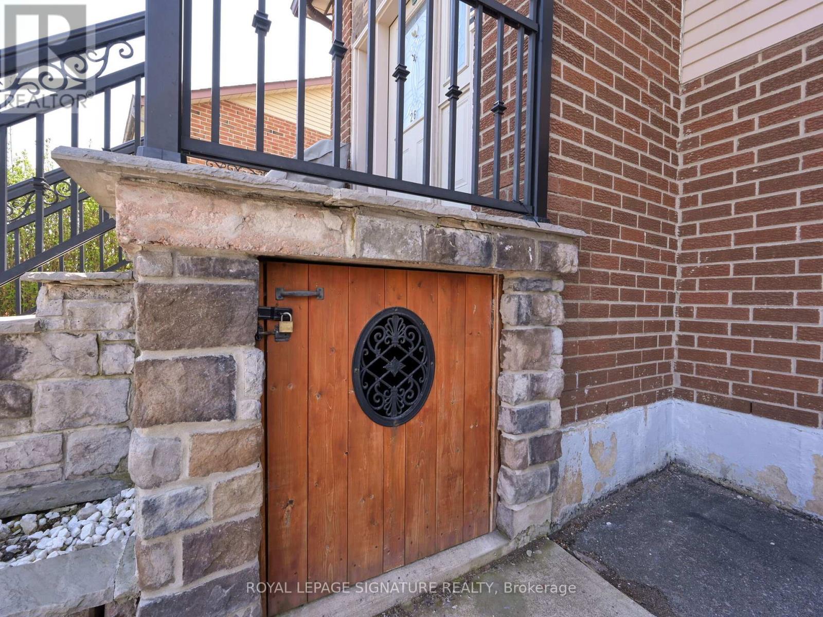 A brown door with a black iron gate is closed.