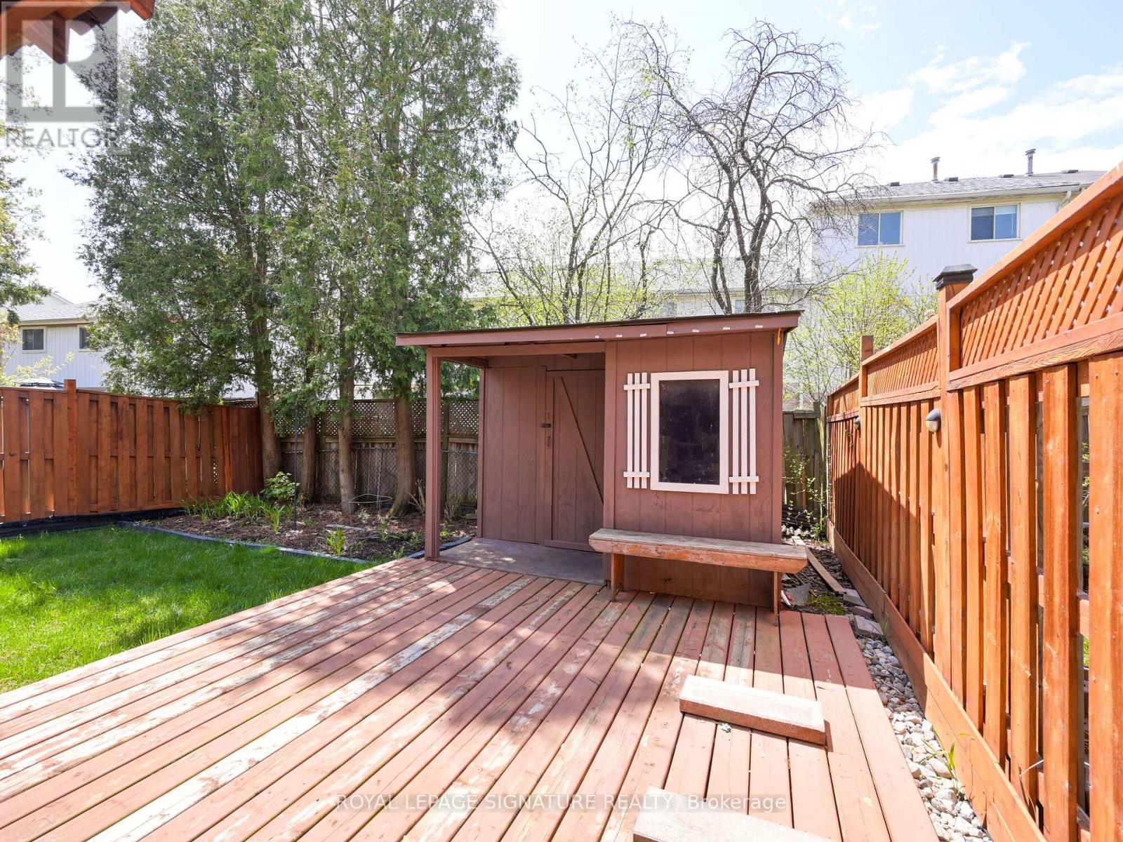 A wooden deck with a small building and a bench.
