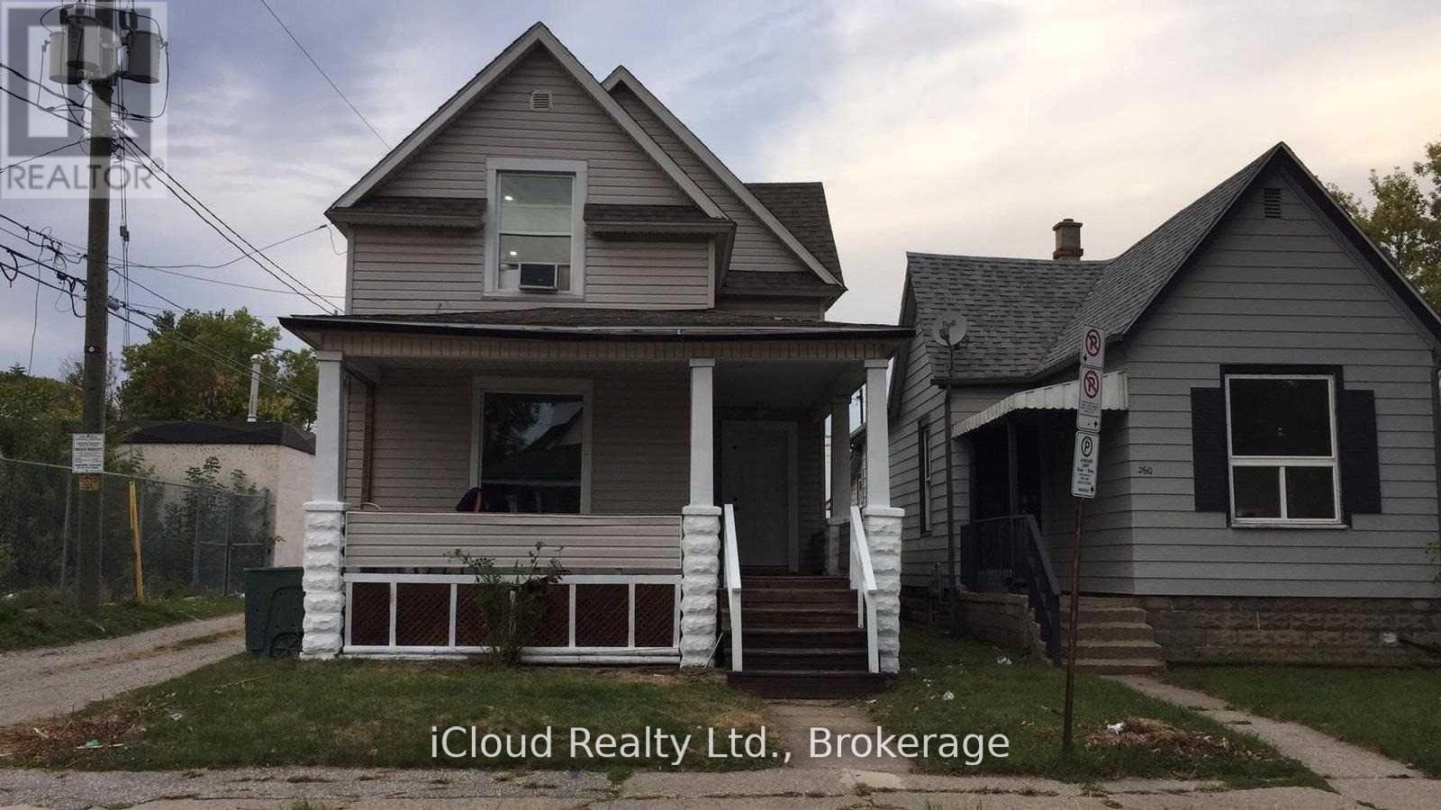 A house with a porch and a sign that says iCloud Realty Ltd., Brokerage.