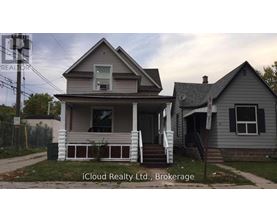 A house with a porch and a sign that says iCloud Realty Ltd., Brokerage.