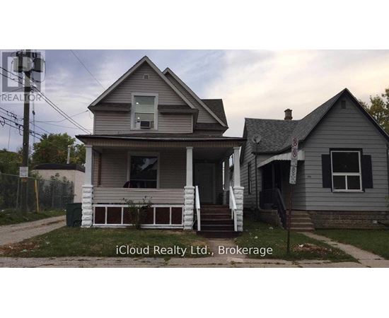 A house with a porch and a sign that says iCloud Realty Ltd., Brokerage.