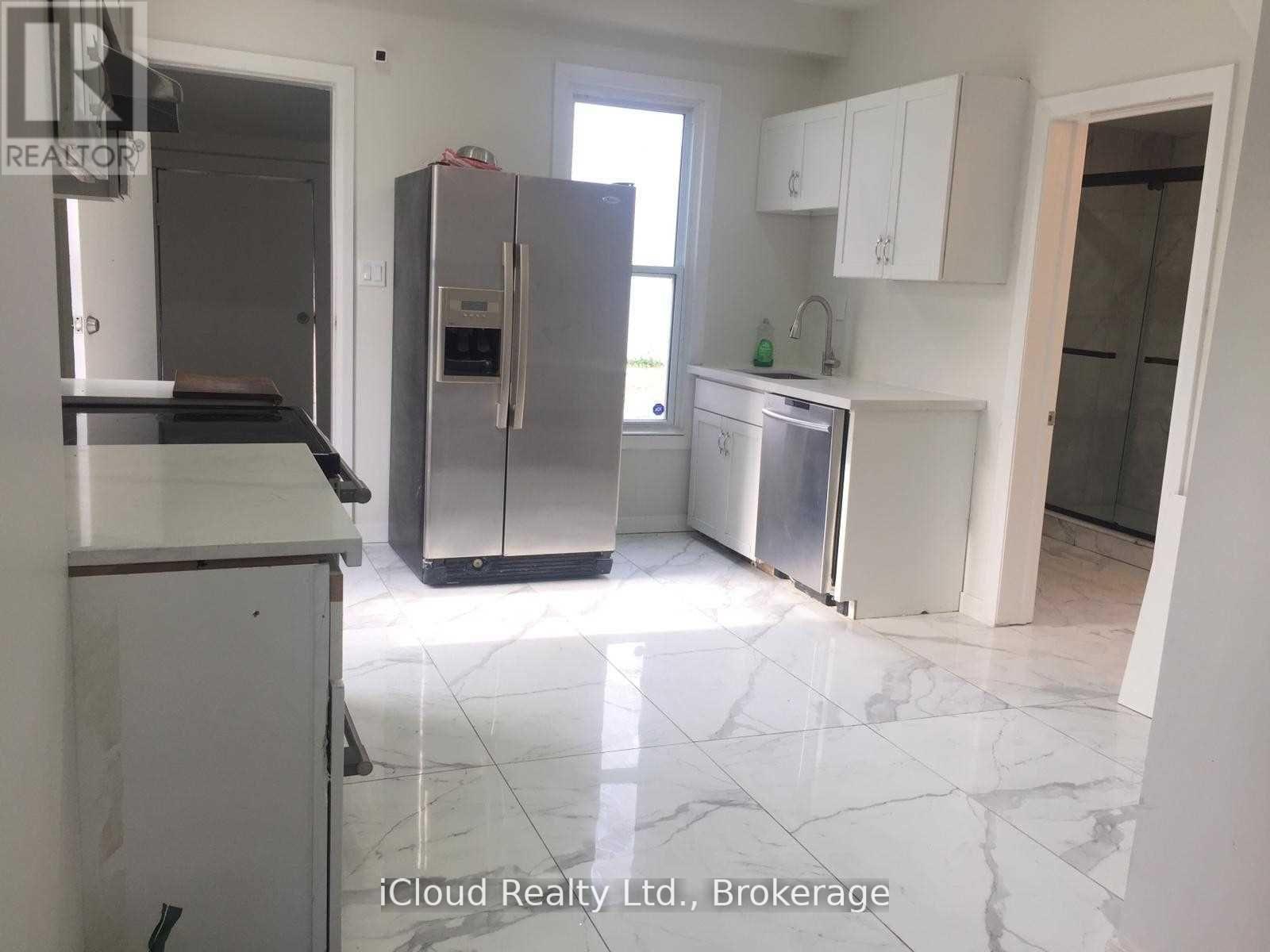 A kitchen with a refrigerator, stove, and sink.