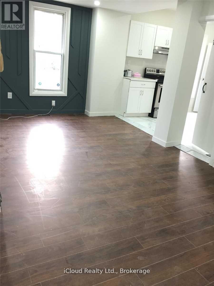 A room with wood flooring and a window.