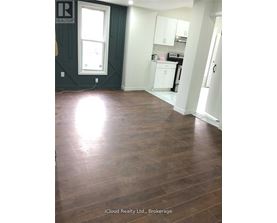 A room with wood flooring and a window.