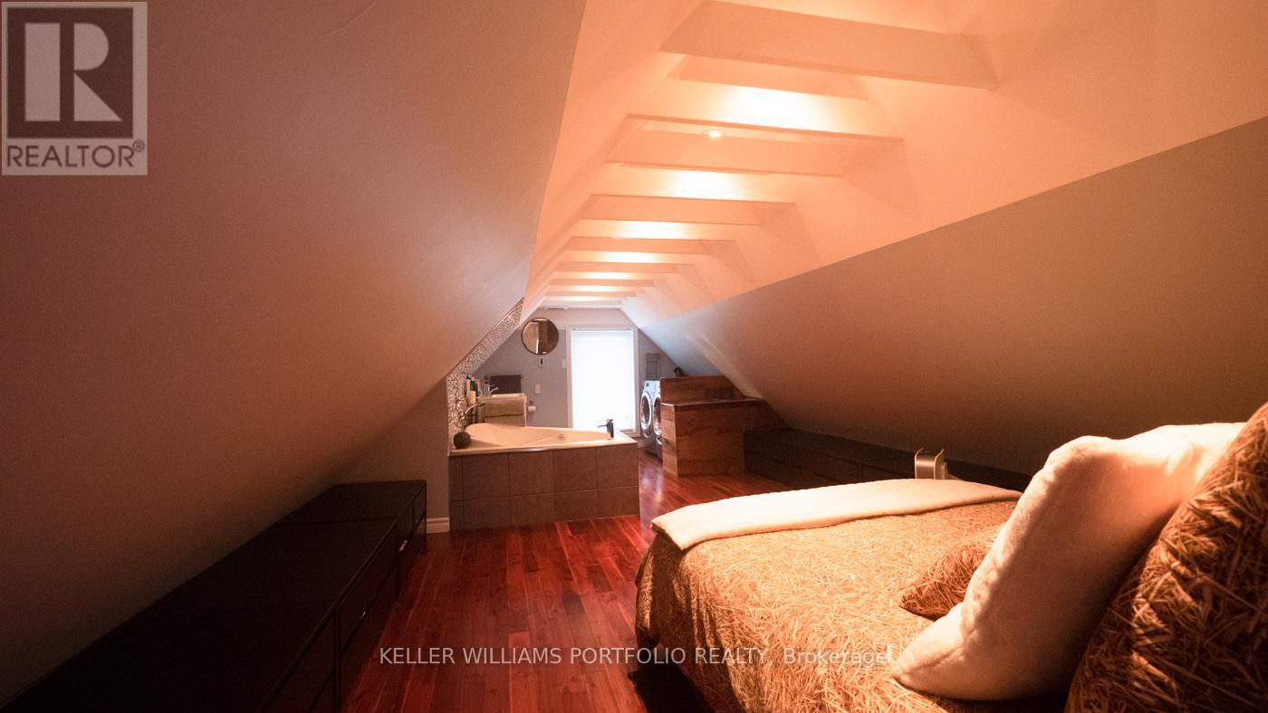 A well-lit bedroom with a bed and a dresser is shown.