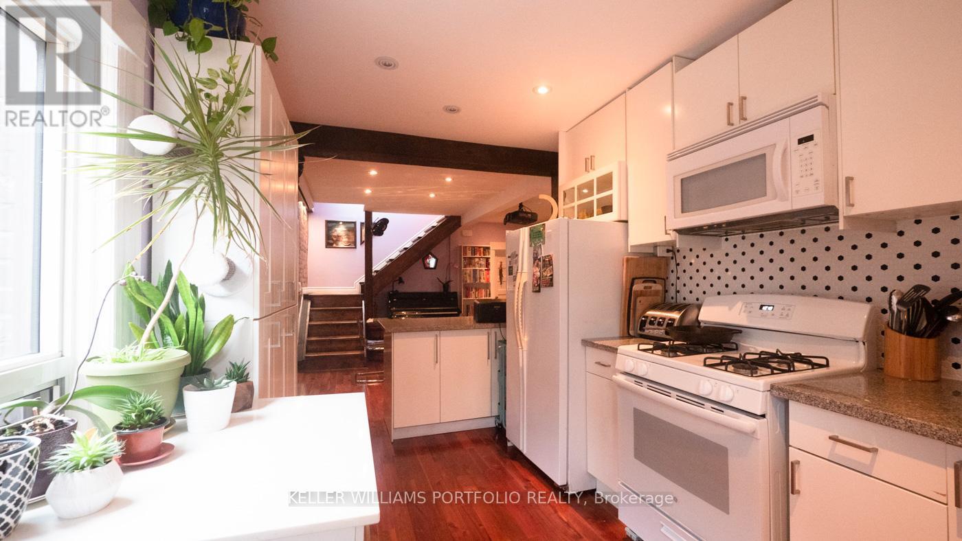 A kitchen with white cabinets and a stove top oven.
