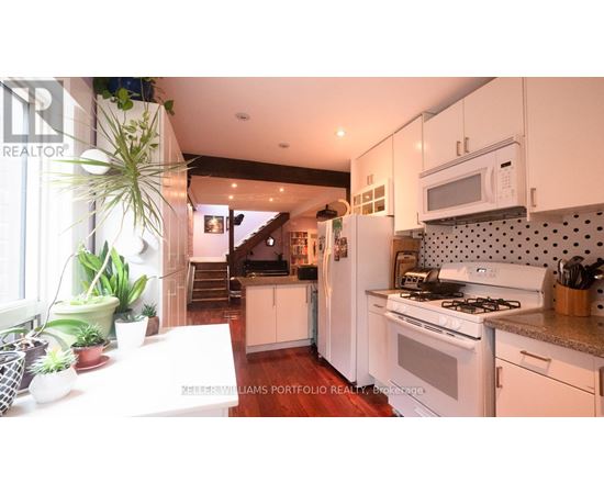 A kitchen with white cabinets and a stove top oven.