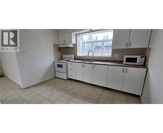 A kitchen with white cabinets and appliances.