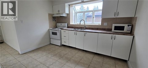 A kitchen with white cabinets and appliances.