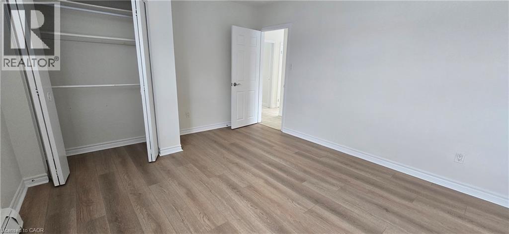 A bedroom with a white door and a wooden floor.