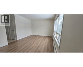 A room with wooden flooring and a window on the right side.