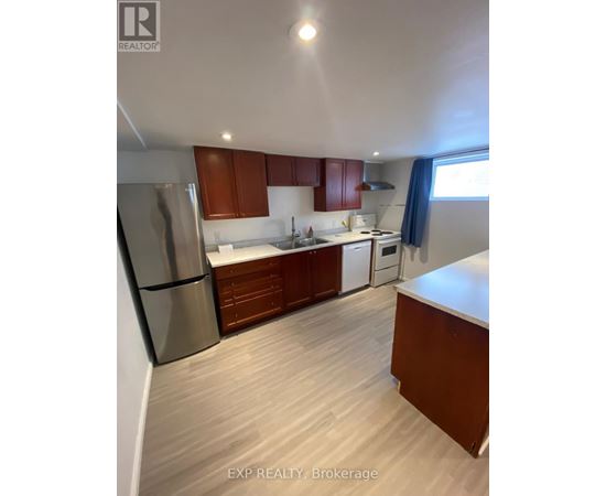 A kitchen with wooden cabinets and a stainless steel refrigerator.