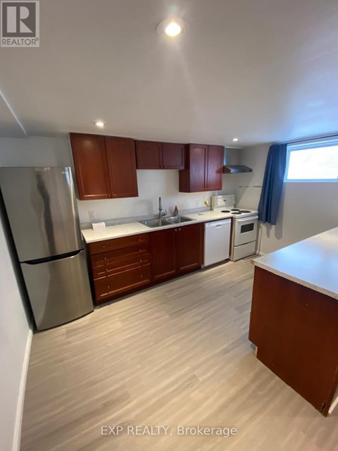 A kitchen with wooden cabinets and a stainless steel refrigerator.