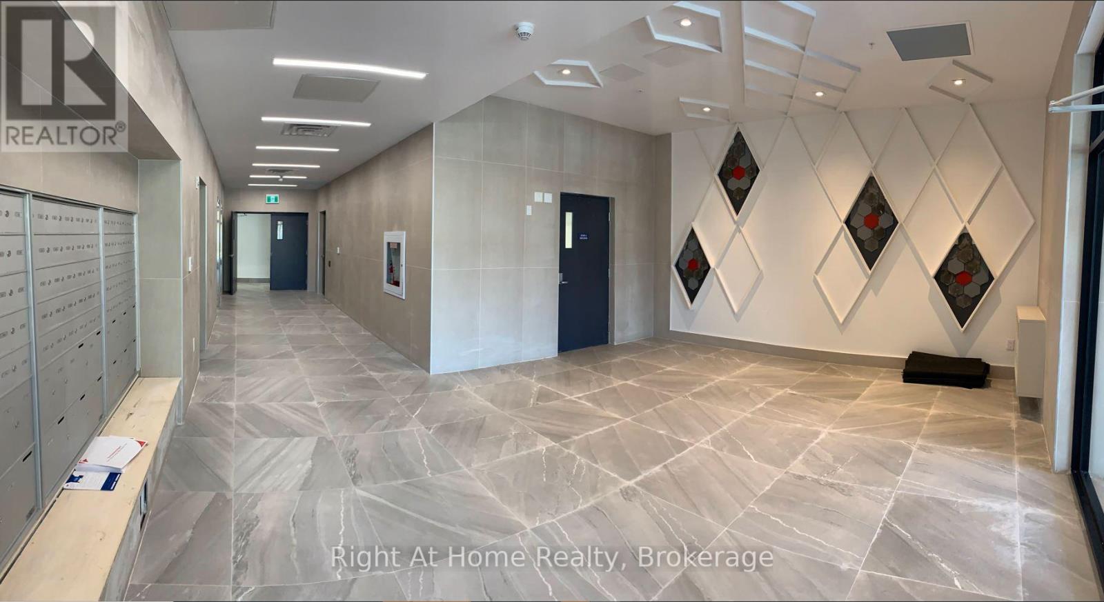 A hallway with a tiled floor and a wall with diamond-shaped decorations.