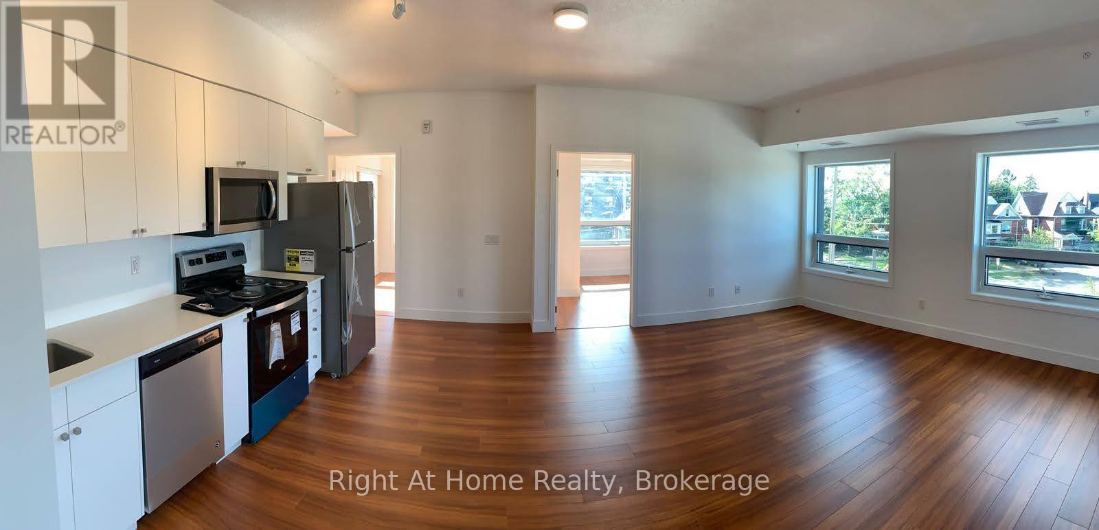A large open living space with wood floors and white walls.