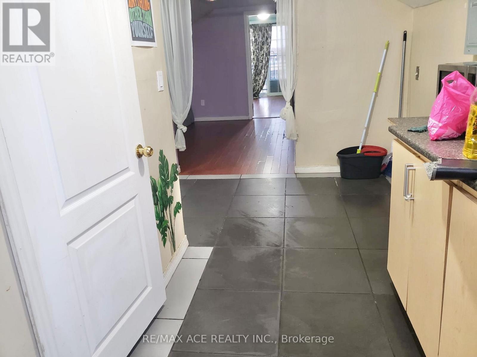 A clean, empty hallway with a broom and mop in a home.