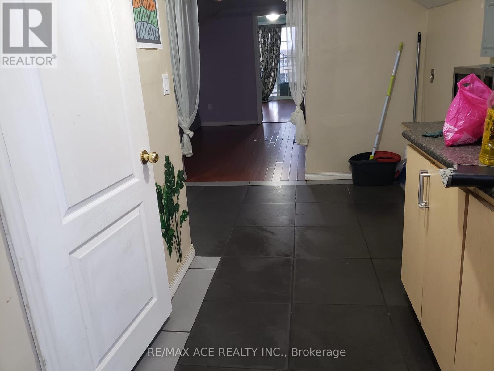 A hallway with a broom and a mop in a home.