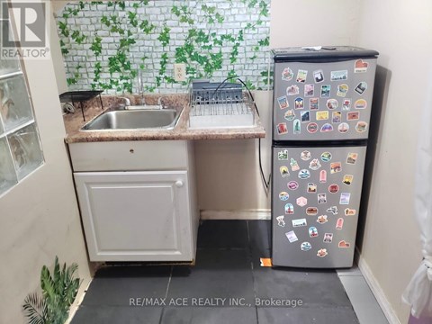 A small kitchen with a sink and a refrigerator with many magnets.