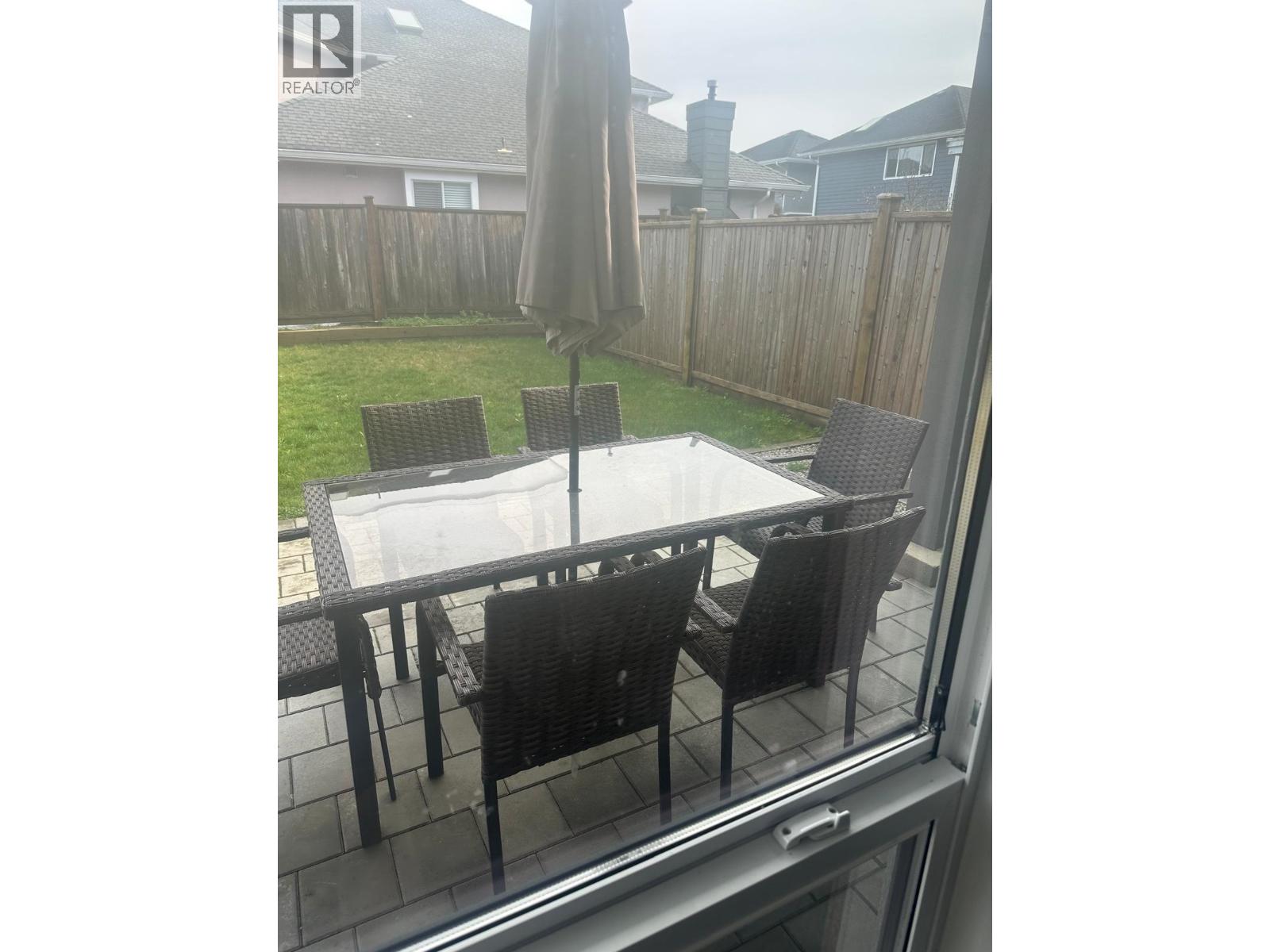 A table with chairs and an umbrella on a balcony.