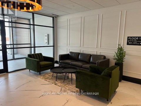 A living room with a green couch and a black leather couch.