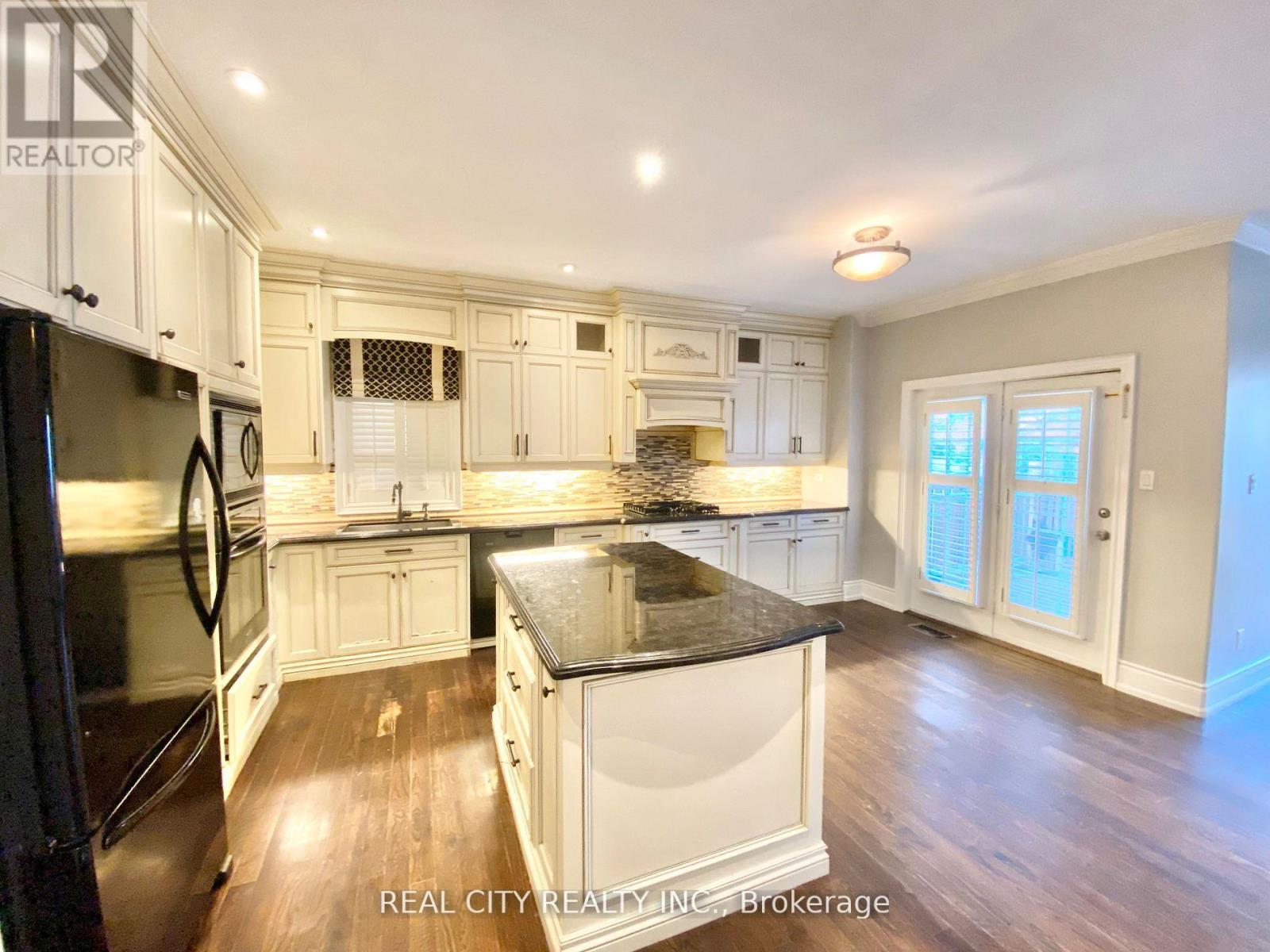 A kitchen with white cabinets and a black countertop.