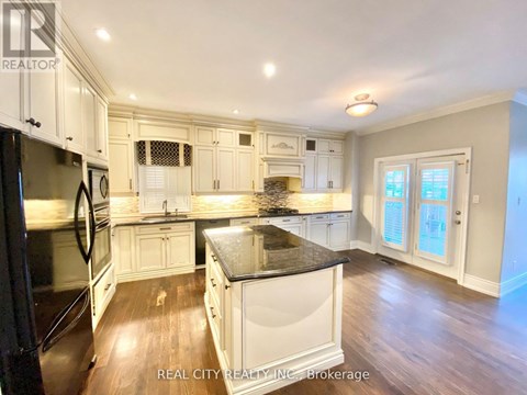 A kitchen with white cabinets and a black countertop.