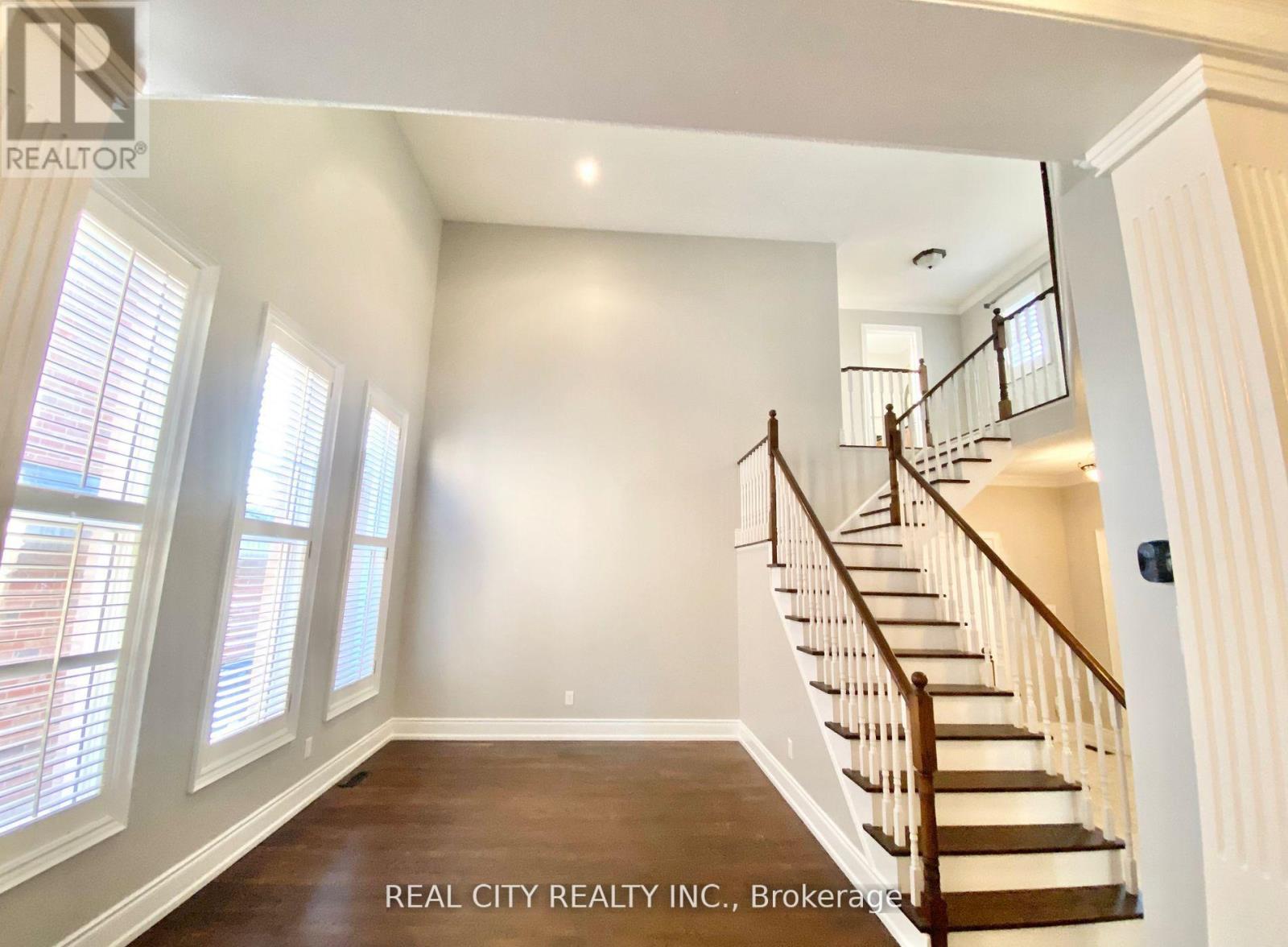 A spacious room with a staircase leading to the upper floor.