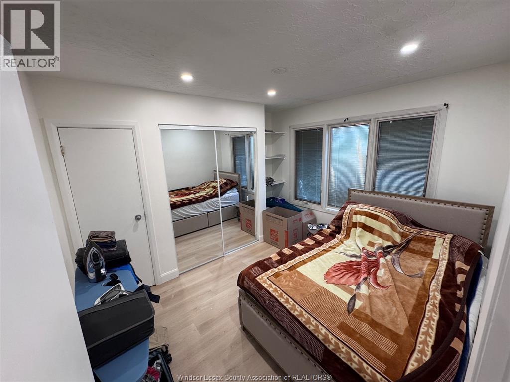 A bedroom with a bed, dresser, and mirror.