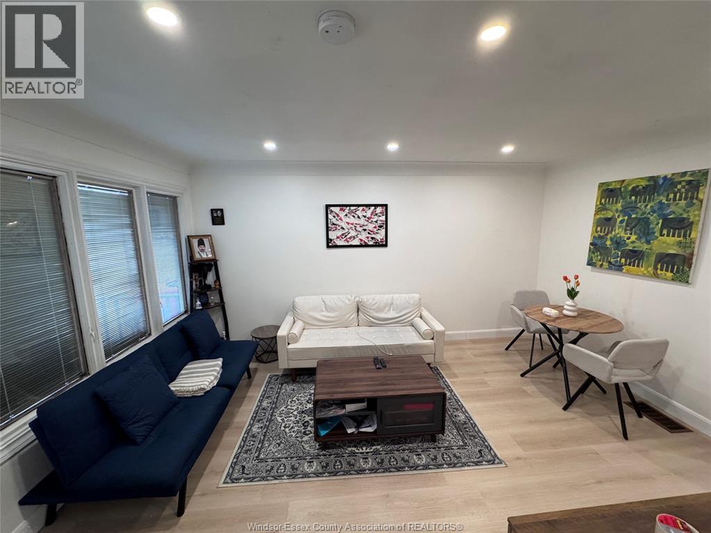 A living room with a blue couch, a white sofa, a coffee table, and a rug.