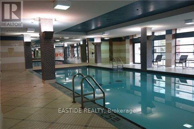 A pool inside a building with a REALTOR sign.