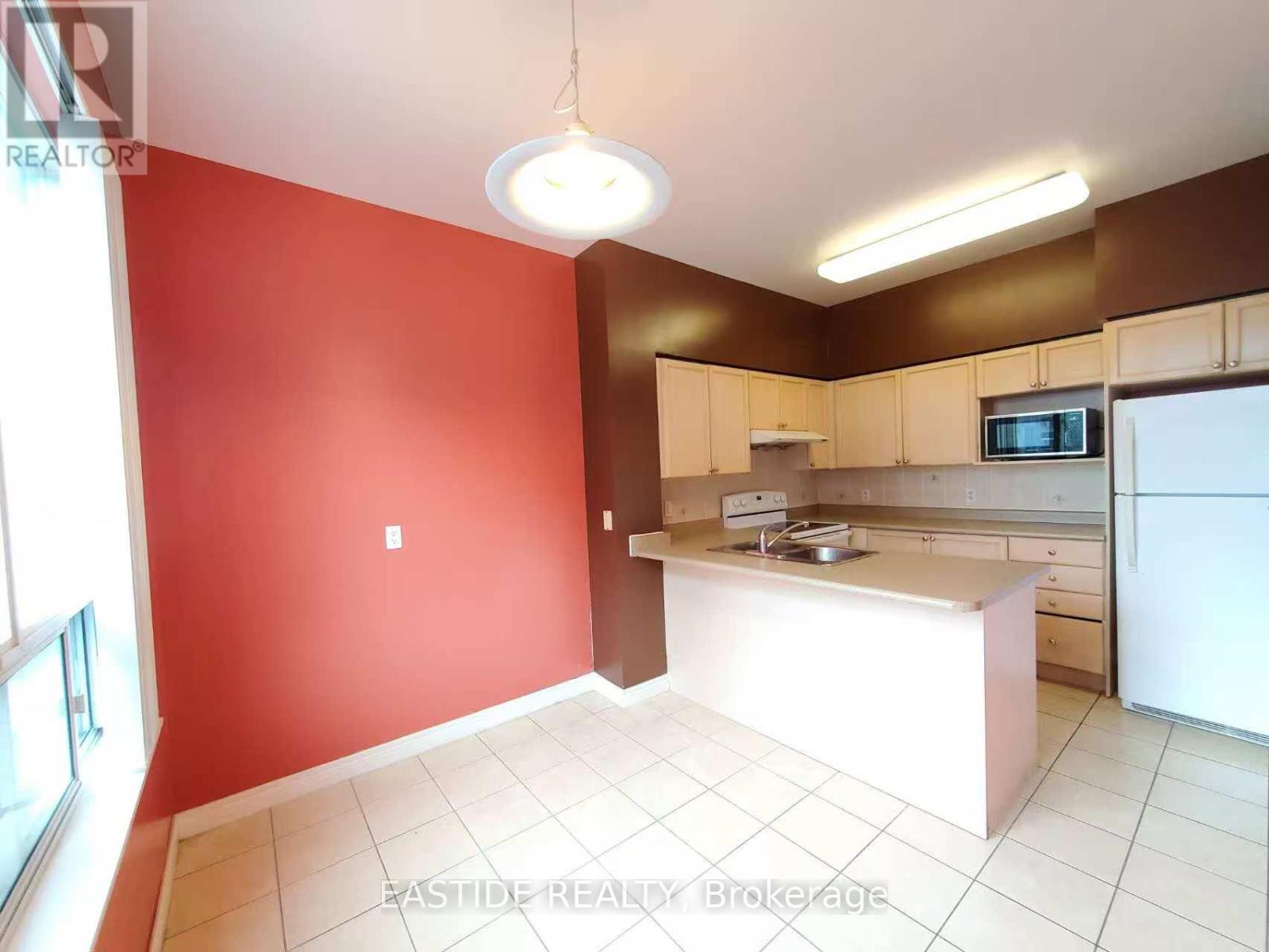 A kitchen with red walls and white appliances.