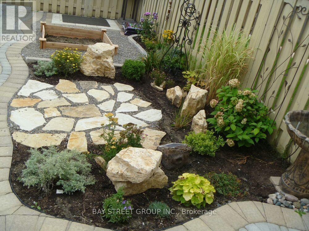 A garden with a stone walkway and a bench.