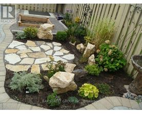 A garden with a stone walkway and a bench.