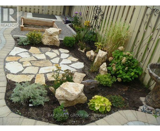 A garden with a stone walkway and a bench.