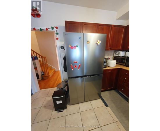 A stainless steel refrigerator with magnets and magnets on it in a kitchen.